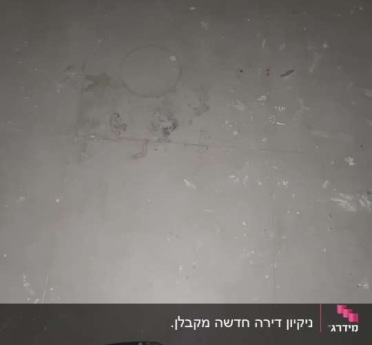 רצפת אריחים מלוכלכת בנתזי צבע ואבק לפני עבודת ניקוי וקרצוף